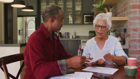 senior african american husband and mixed race wife working together at home