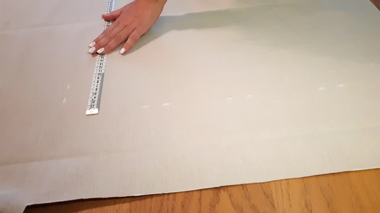 primer plano de las manos de sastre femenina tomando la medida con regla sobre tela blanca, preparación para coser, estática con espacio de copia