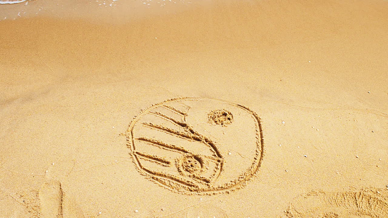 Yin e Yang sulla sabbia, in spiaggia. Scatto in spiaggia.