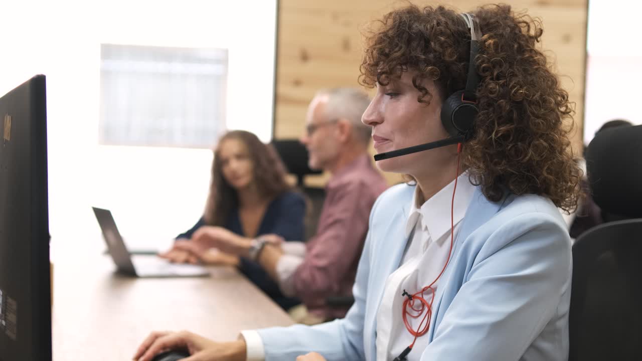 Confident businesswoman talking as she wears headset in coworking office