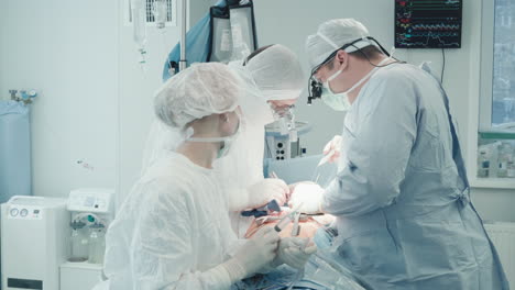 surgical team performs surgery on heart. cardiothoracic surgeon with assistants works on arteries during coronary artery bypass surgery in clinic