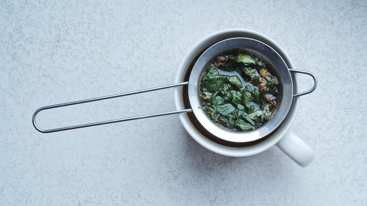 Soothing cup of peppermint-linden tea with strainer, perfect for winter wellness