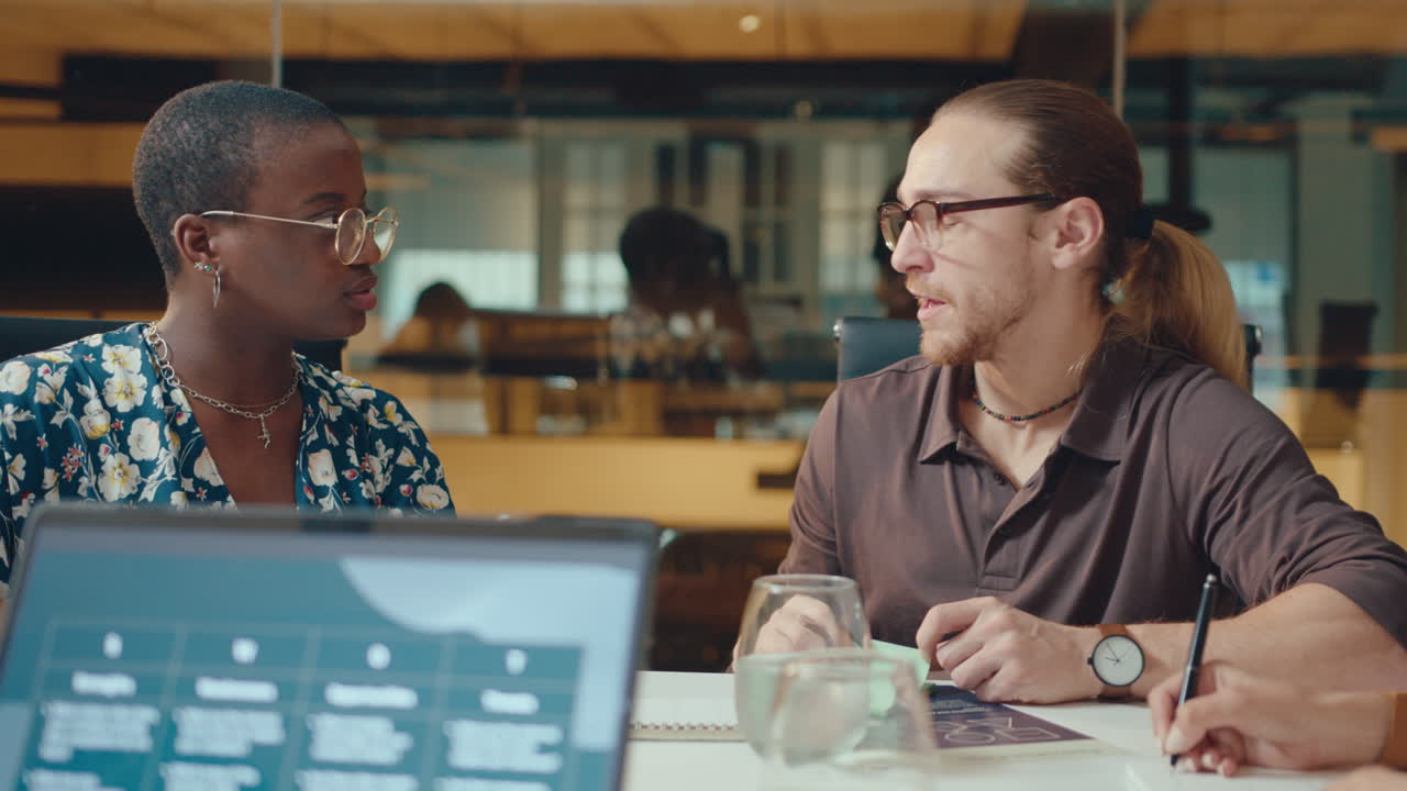 Young Black Businesswoman Speaking with Coworker in Meeting Room