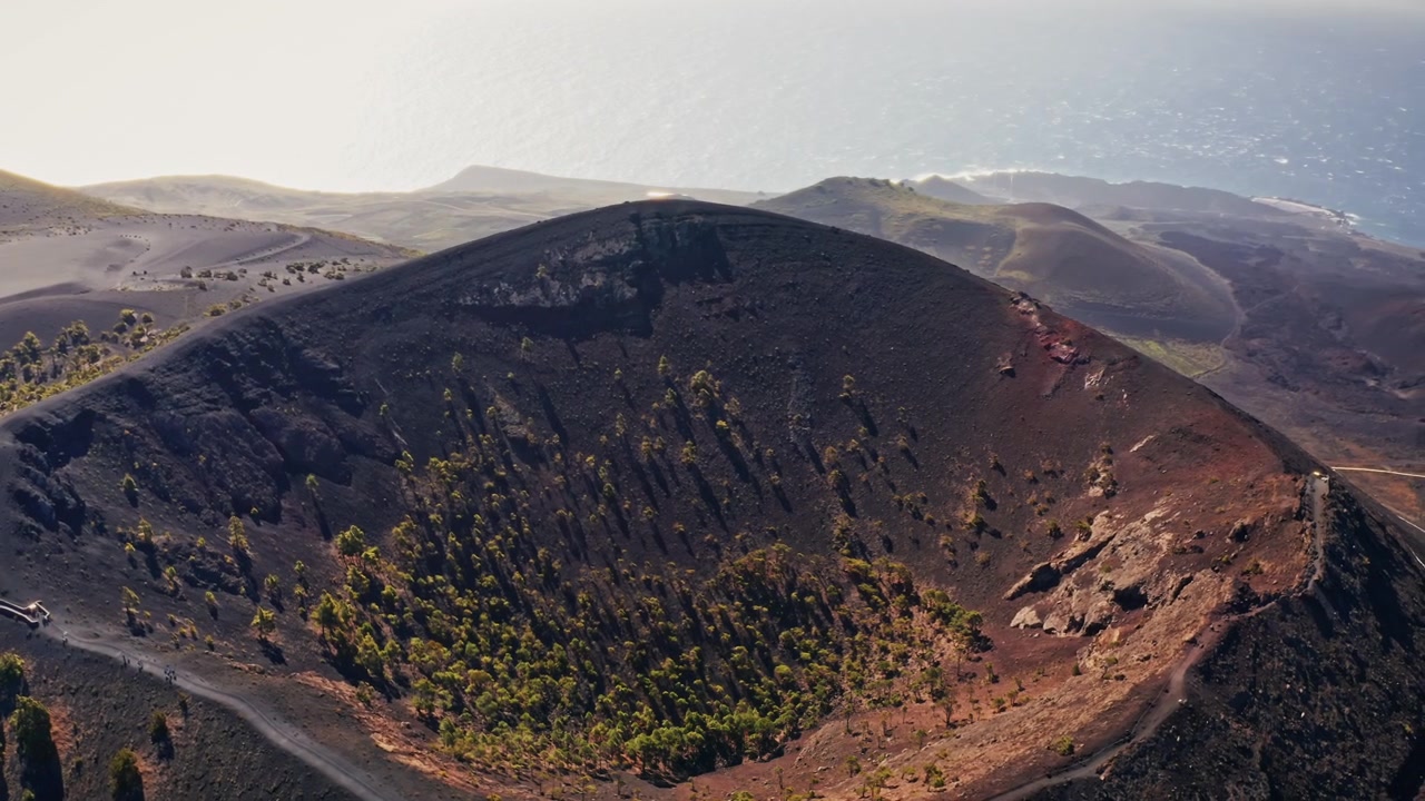 Ripresa aerea con drone sopra il Vulcano di San Antonio nell'isola di La Palma, Isole Canarie, Spagna. Vista dall'alto del cratere e del paesaggio vulcanico aspro. Vista della costa sullo sfondo.