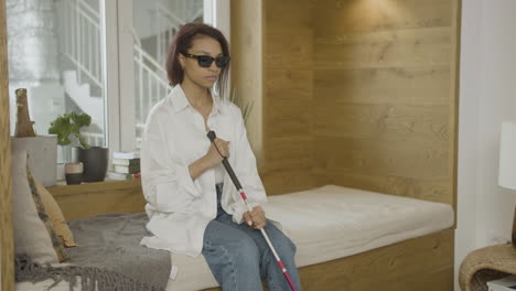 young blind woman sitting on the bed