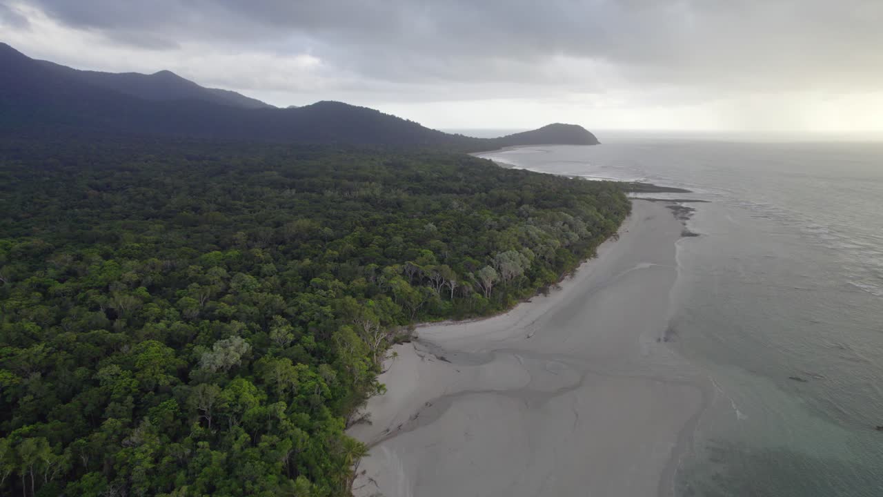 playa y jungla contra el cielo nublado en el parque nacional daintree, lejano norte de queensland, australia - toma aérea de drones