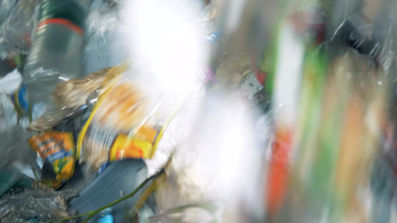 재활용 센터의 쓰레기 공장 장비는 많은 쓰레기를 분류하는 동안 회전합니다.