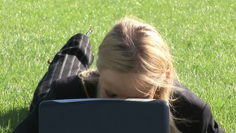 young attractive blond woman on laptop outdoors