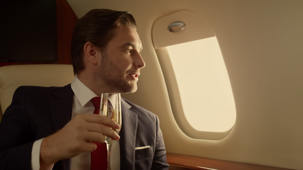 Uomo ricco che viaggia in jet bevendo champagne, primo piano. Uomo affascinante ad un appuntamento romantico.