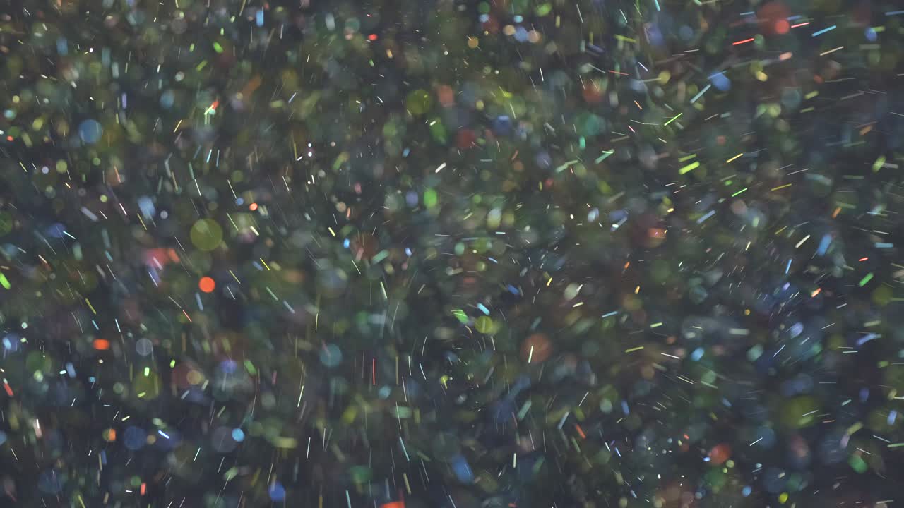 빛나는 다채로운 입자가 공중에 떨어지는 느린 모션