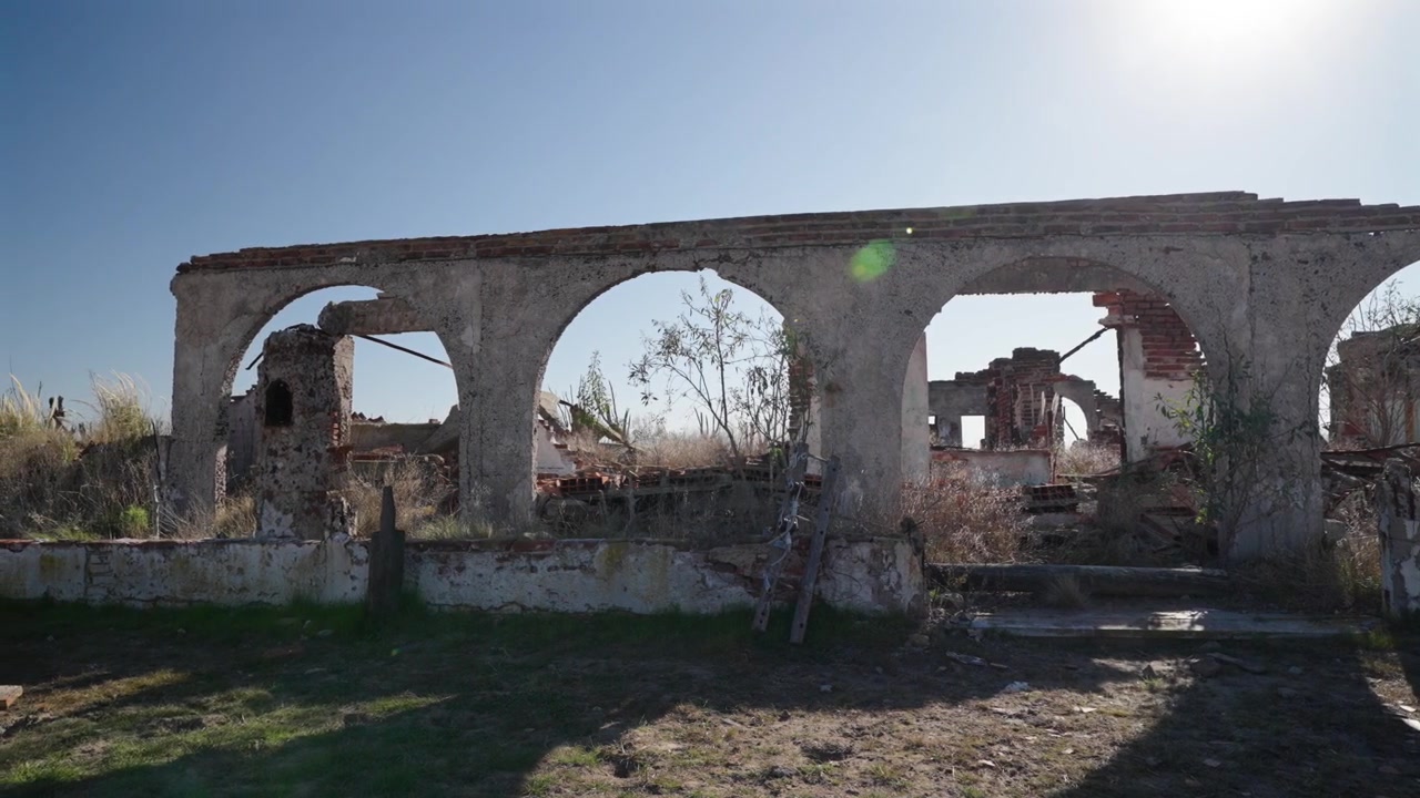 Vnější pohled na rozpadající se kamenné oblouky a zničené budovy v městě duchů Epecuen.
