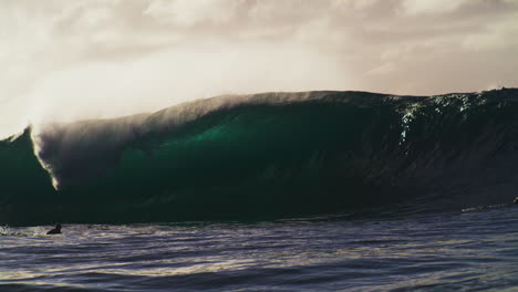 Ocean-spray-mists-off-top-of-barreling-wave-at-sunset