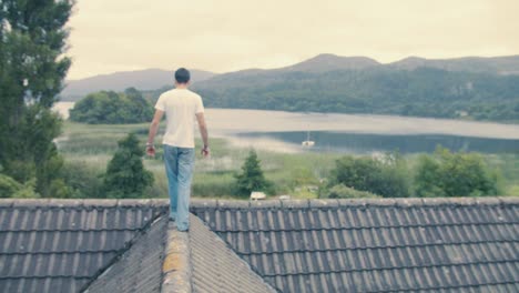 a man walks along his rooftop overlooking a beautiful picturesque lake view