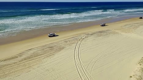 Smooth,-sweeping-shot-of-cars,-four-wheel-driving-on-the-beaches-of-the-iconic-Fraser-Island-on-a-beautiful-summer�s-day-in-Australia