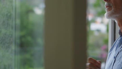 Upset senior man looking through window 4k