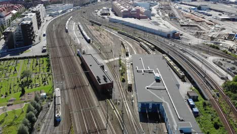 aerial flyover of tram passing through gothenburg rail yard and tracks