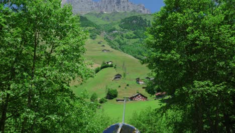 Cable-Running-Down-Swiss-Lush-Green-Valley-Over-Cabins