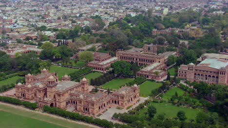 hermosa vista aérea del antiguo edificio universitario con la ciudad, vuelo de drones de lado a frente, árboles verdes y bosque con el edificio, un hermoso castillo imaginario o vista aérea del palacio del emperador