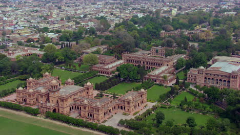 beautiful old college building aerial view with city, drone flight from side to front, green trees and forest with the building, an imaginary beautiful castle or emperor palace aerial view