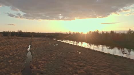 panorama of vast marshland surrounded by woodland at sundown