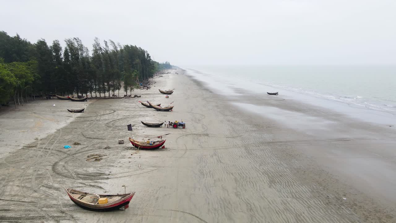 un grupo de pescadores y sus barcos en la playa a lo largo de la costa preparándose para ir al mar