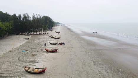 Eine-Gruppe-Von-Fischern-Und-Ihren-Booten-Am-Strand-Entlang-Der-Küste,-Die-Sich-Darauf-Vorbereiten,-Zum-Meer-Zu-Fahren