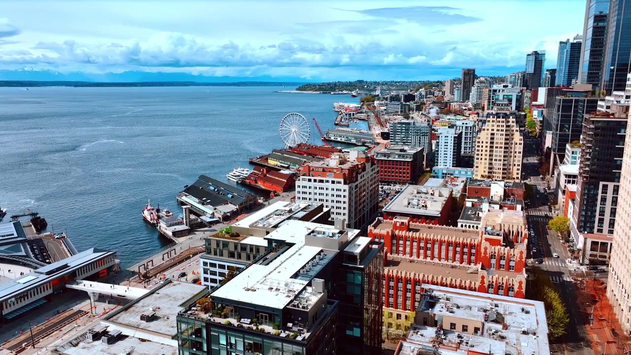 Avvicinandosi al paesaggio acquatico del lago con più moli nel centro di Seattle, Stato di Washington, USA. Città moderna sul lungolago vista dall'alto.