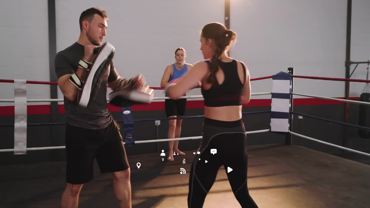 Female boxer advancing after trainer presenting focus pads landing jabs and training in boxing ring