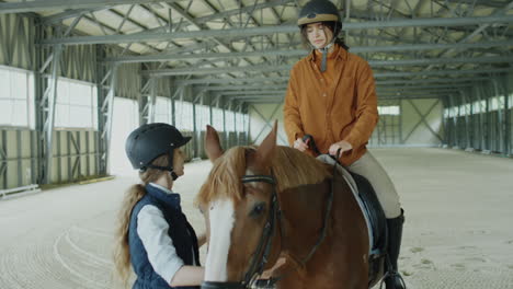woman mounting horse with help of riding instructor