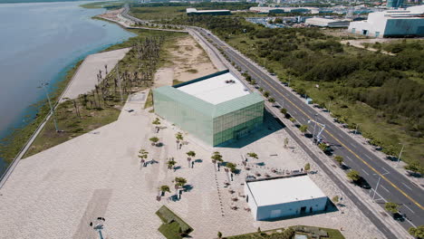 aerial-view-of-Malecon-of-the-Magdalena-River-in-Barranquilla-reveals-its-modern-charm,-adorned-with-a-mirrored-building-reflecting-the-city's-contemporary-spirit