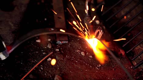 closeup of welder soldering filler material for bonding metal together using flame torch