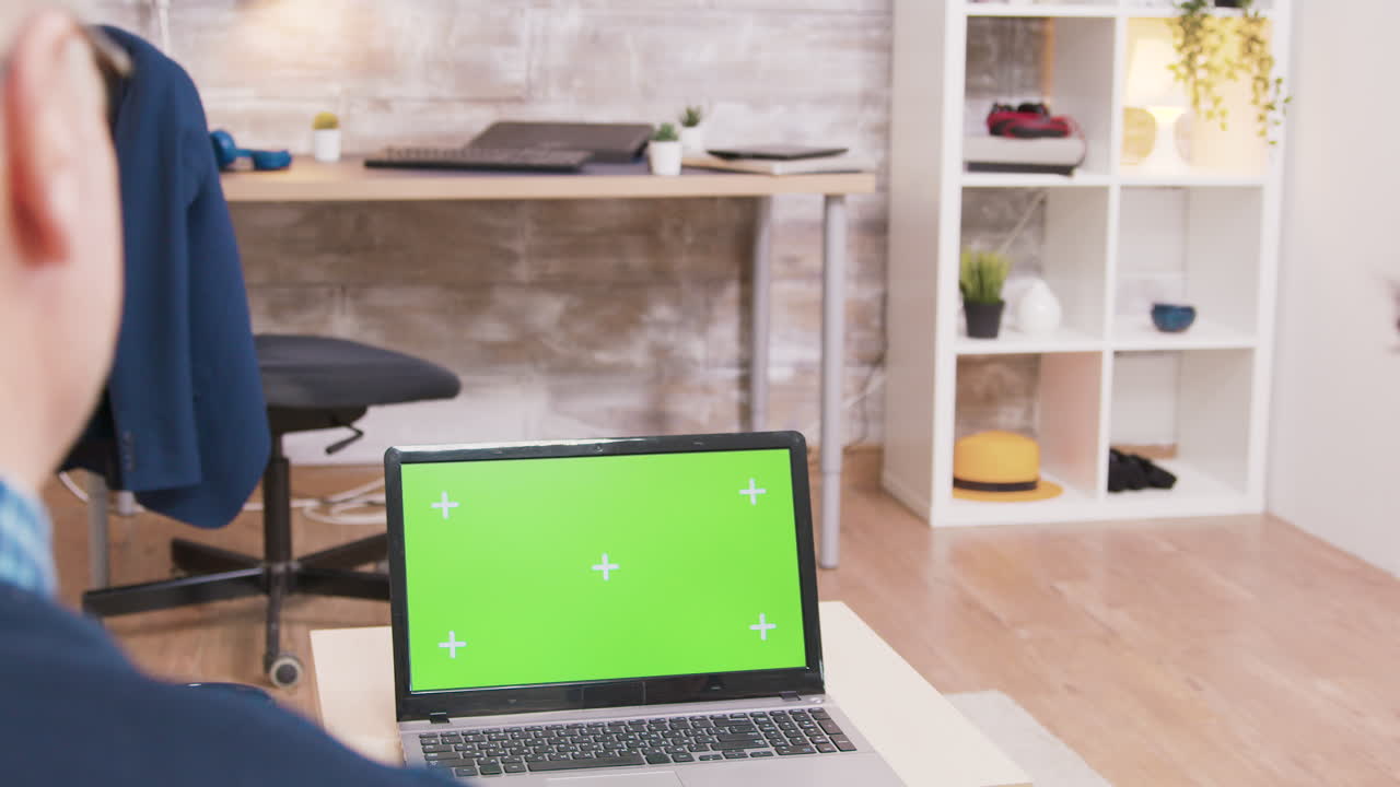 Laptop with green screen in a workspace