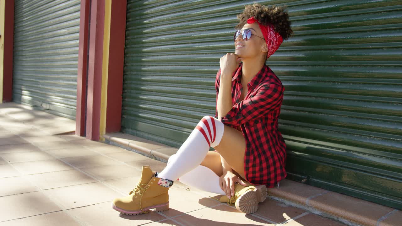 울타리 에 앉아 있는 멋진 아프리카계 미국인 소녀