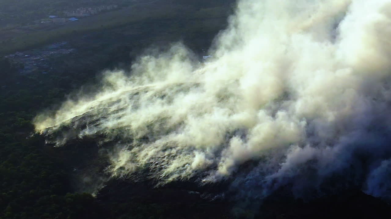 Aerial view around a white smoke cloud caused by a wildfire, Climate emergency., in LA, California, USA - orbit, drone shot