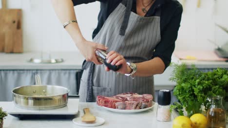 Woman-grinding-spices-on-raw-beef-shank-in-kitchen