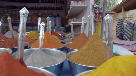 close up overview across lots of vibrant colourful herb - spice powders in outdoor store market scene