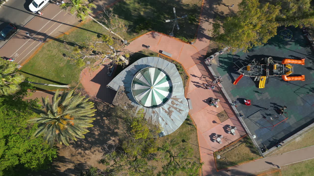 Vista aérea de un vibrante parque urbano con zona de juegos y carrusel
