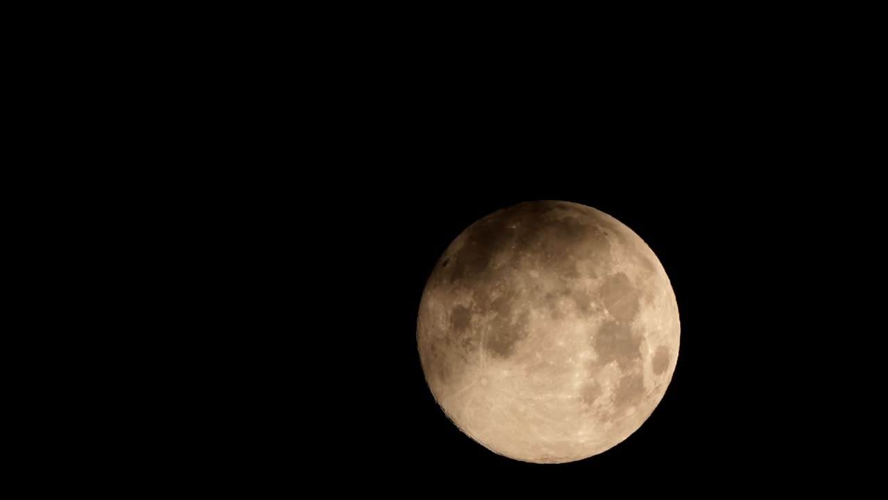 Close-up de uma lua rosa nascente contra um céu noturno escuro como breu