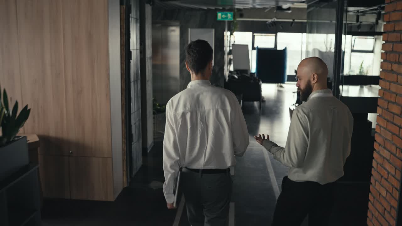 Due uomini che camminano nel corridoio di un ufficio