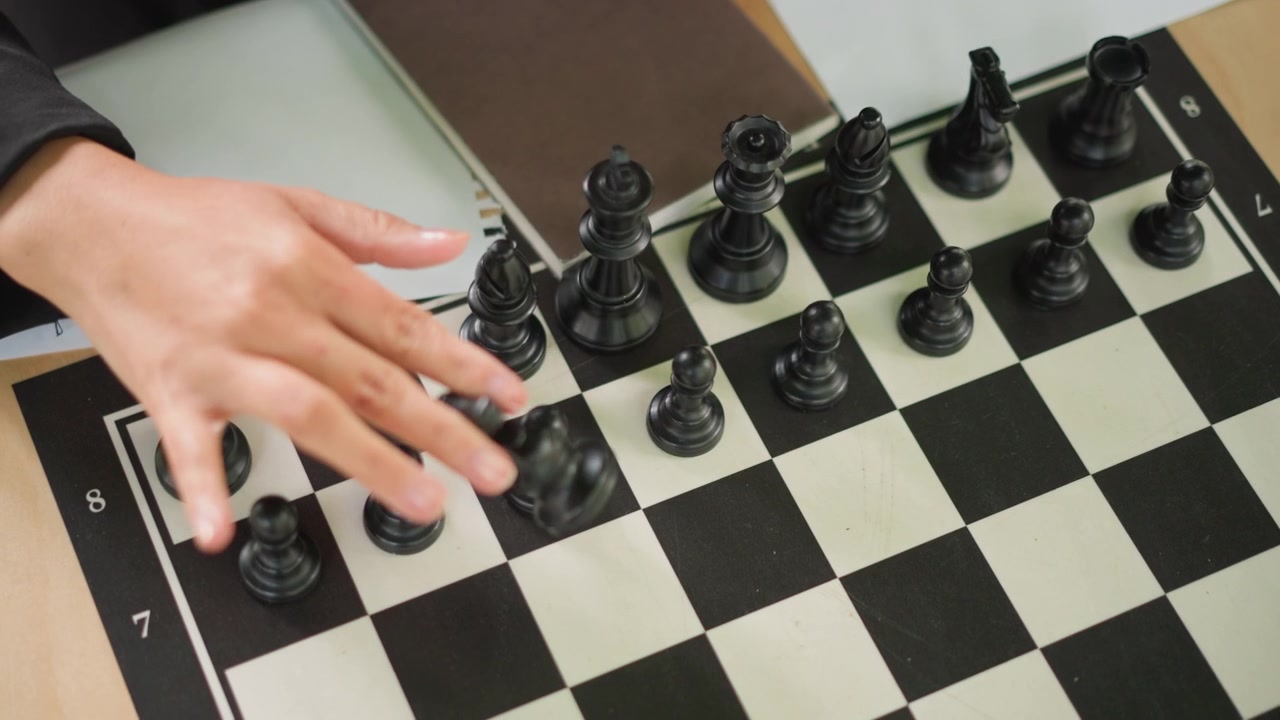 Primo piano di una giovane ragazza che gioca a scacchi, muovendo i pezzi neri sulla scacchiera. La scena include una vista dettagliata dell'interazione delle mani con gli elementi del gioco come pedoni e torri in corso. Illuminazione soffusa.