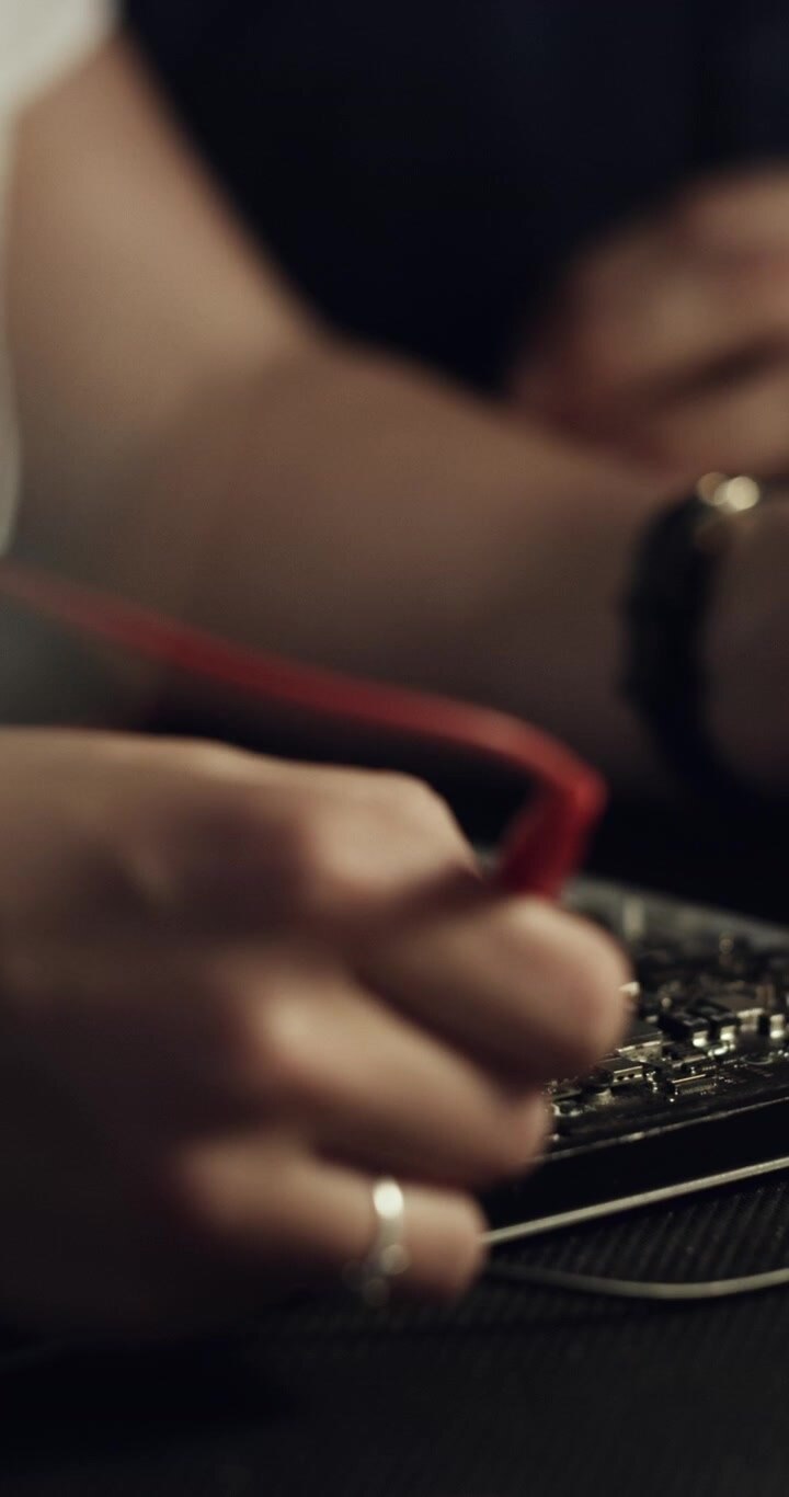 Technician Testing Electronic Circuit Board with Multimeter Probe