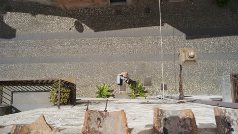 mujer joven llamando a la puerta turista sosteniendo equipaje visitando vacaciones llegando al destino usando un teléfono inteligente para direcciones vista superior