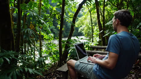 man working on laptop in nature