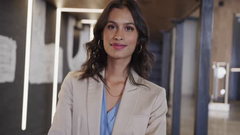 retrato de una feliz mujer de negocios biracial en la oficina, cámara lenta