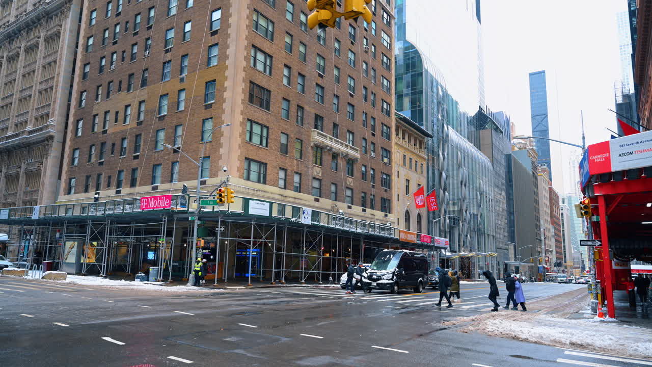 New York, USA, 22 dicembre 2025: vista invernale della strada vicino alla Carnegie Hall di New York. Banner rossi e blu con edifici in vetro e marciapiedi innevati lungo la trafficata 7th Avenue