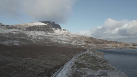 Snow-capped-mountain-overlooking-railway-track-and-lake,-clear-sky,-Scotland