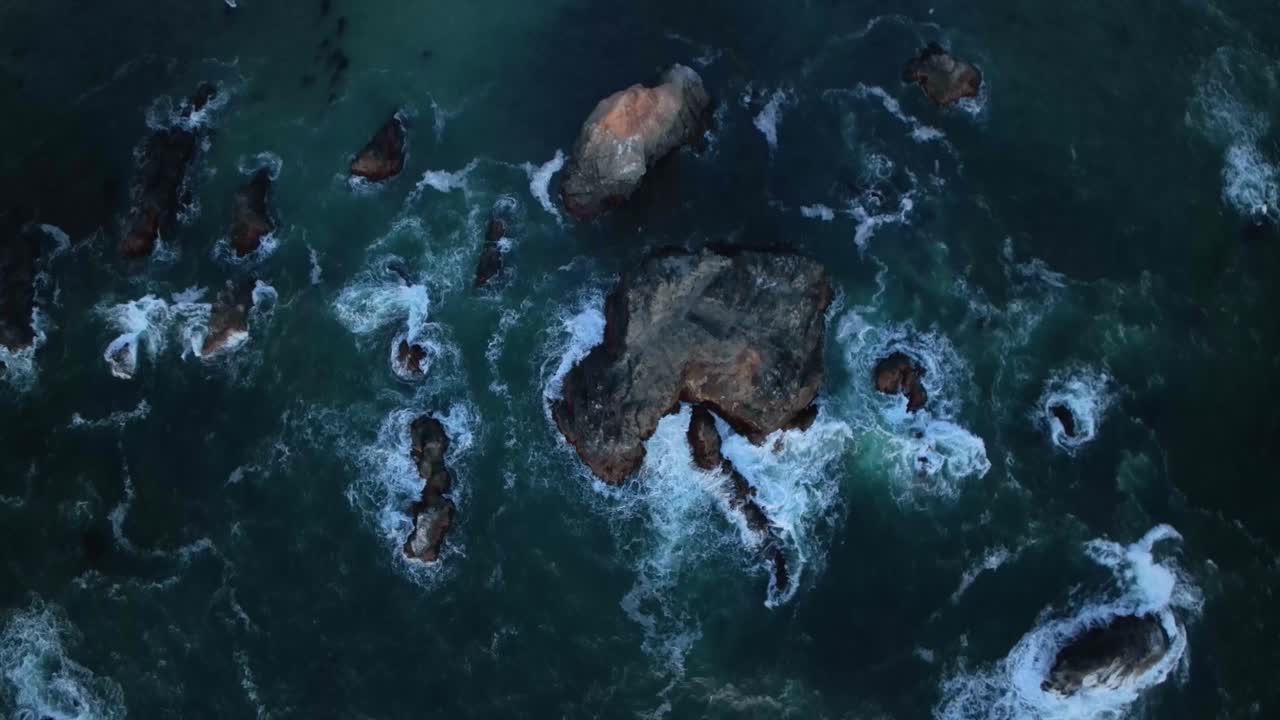 vista aérea de arriba hacia abajo de una costa llena de rocas frente a la costa de california