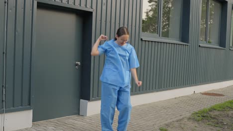 female nurse steps out of work and starts to dance