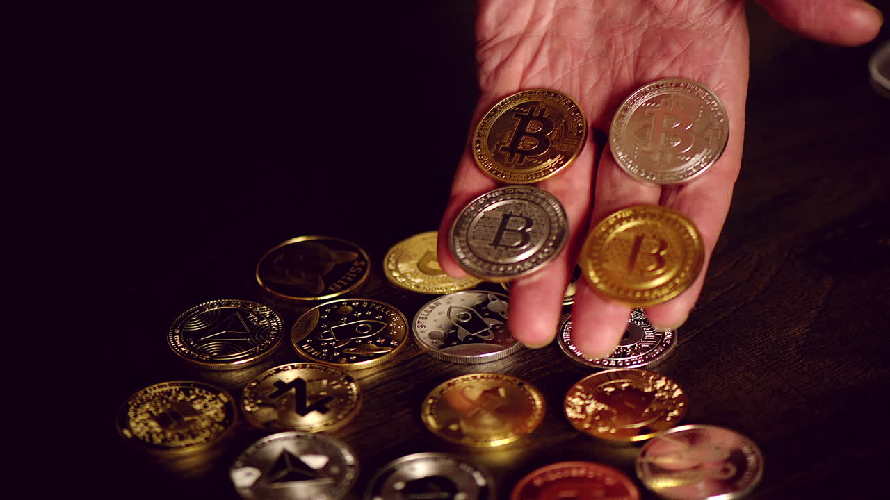Man hand holding crypto coins and golden bitcoin on a table
