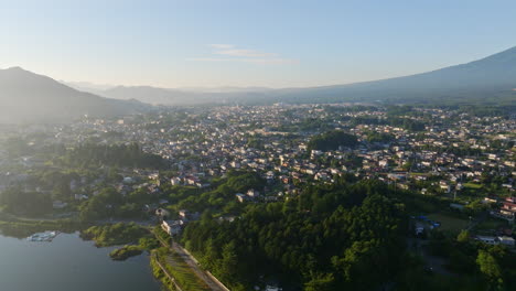 drone girando sobre el lago kawaguchi hacia la ciudad de fujiyoshida, amanecer en japón